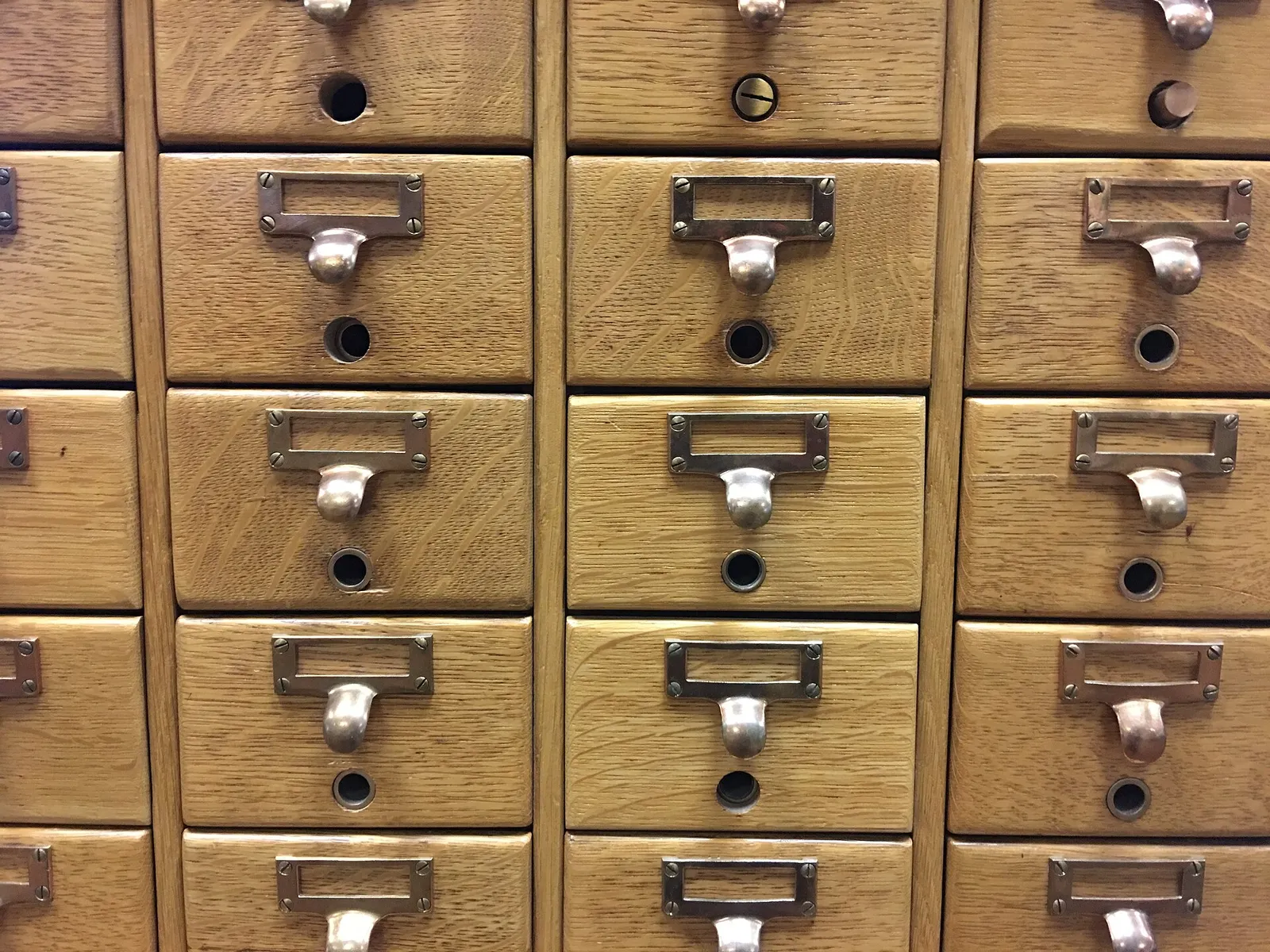 Un meuble à fiches en bois, aux dizaines de tiroirs